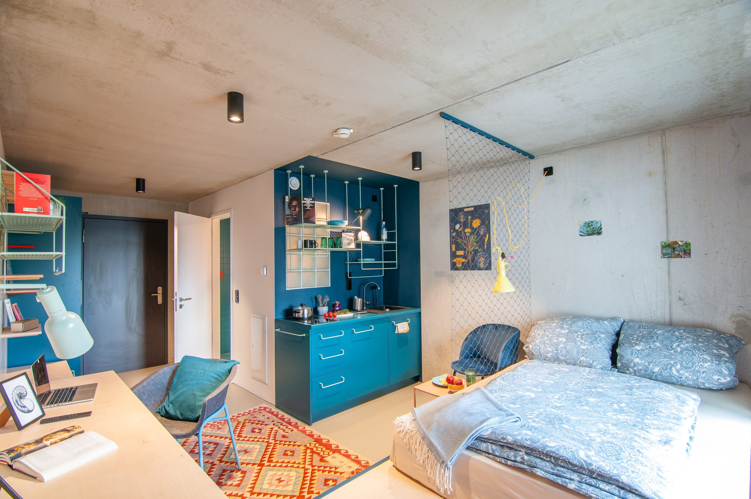 Schlafzimmer mit Doppelbett und Küchenzeile
