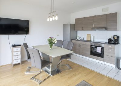 Monteurzimmer Küche mit TV und Sitzgruppe